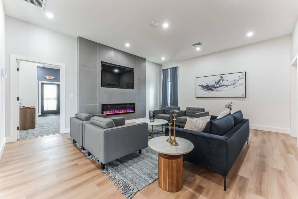 A cozy lounge area with a modern electric fireplace, plush sofas, and a coffee table, creating a warm and inviting atmosphere in mesa az